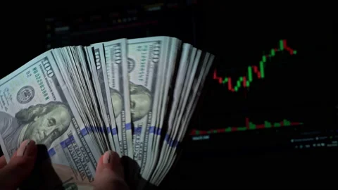 Stack of Dollars in a Hand on the Background of a Stock Market Chart Stock Footage 201340315