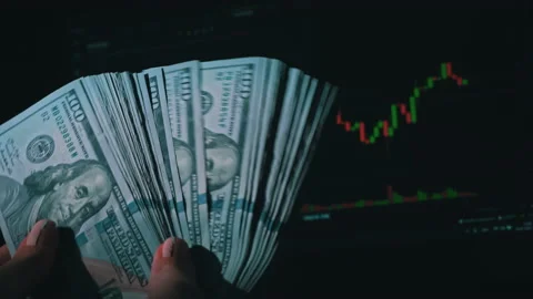 Stack of Dollars in a Hand on the Background of a Stock Market Chart Stock Footage 201351305