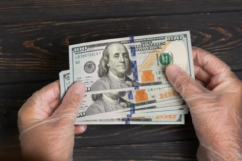 Stack of dollars USA in gloved hands Stock Photos