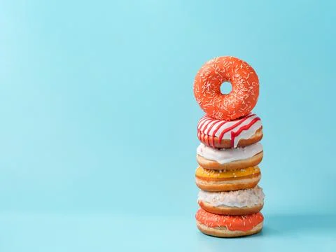 Stack of donuts on blue background with copy space Photos