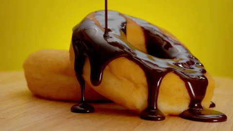 Stack of donuts with chocolate cream on a rotating wooden plate. Stock Footage 147738118