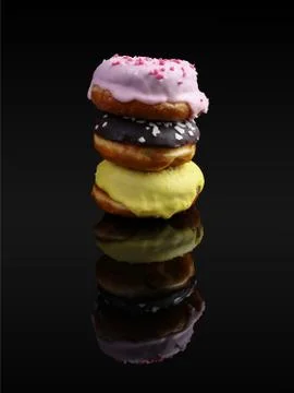 A stack of donuts with icing and chocolate powder, reflected in the mirror. O Stock Photos