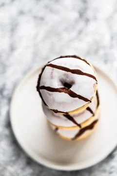 Stack of donuts on a white plate. Donuts with white chocolate frosting , glaz Stock Photos