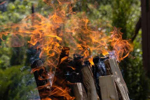 A stack of dry firewood burning with a bright red flame against a background  Stock Photos