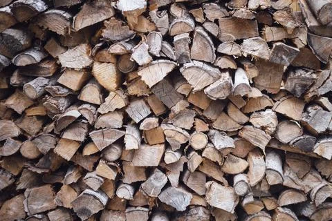 Stack of dry firewood logs chopped and piled for winter heating. Renewable na Stock Photos
