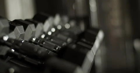 Stack of dumbbells placed on stand in gymnasium Stock Footage 235383493