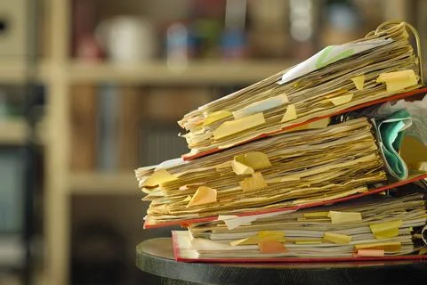 Stack of dusty messy file folders with narrow depth of field, blurred offic.. Stock Photos