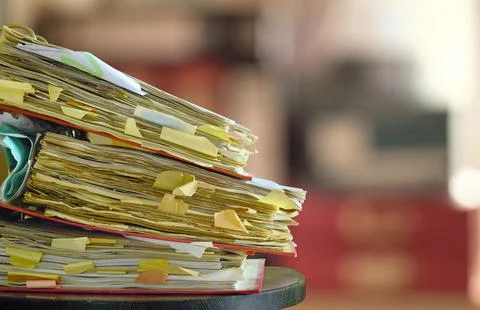 Stack of dusty messy file folders with narrow depth of field, blurred offic.. Stock Photos