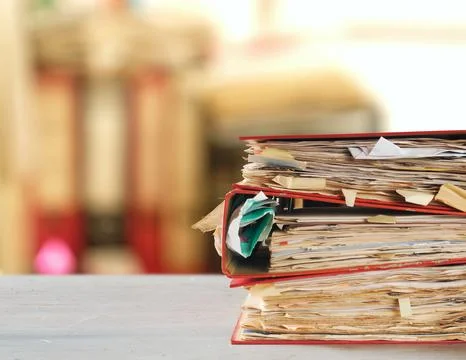 Stack of dusty messy file folders with narrow depth of field, blurred offic.. Stock Photos
