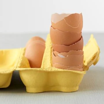 A stack of egg shells in a yellow egg box Stockfoto's