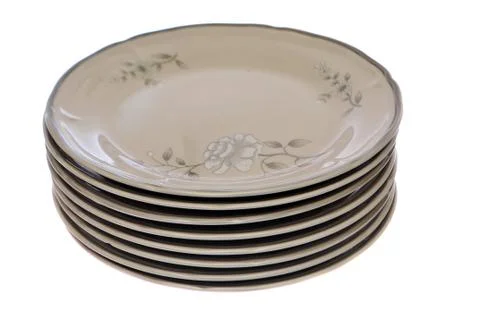 Stack of eight white plates with a flower design on them isolated on white ba Stock Photos