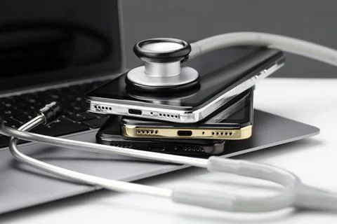 Stack of electronic devices and stethoscope on white table Foto stock