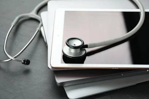 Stack of electronic devices and stethoscope on black table, closeup 写真素材