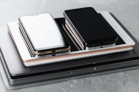 Stack of electronic devices on grey stone table, closeup 库存照片