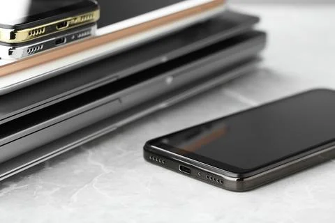Stack of electronic devices on grey stone table, closeup 库存照片