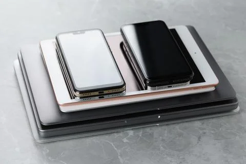 Stack of electronic devices on grey stone table, closeup Foto stock