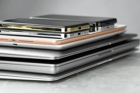 Stack of electronic devices on grey stone table, closeup Foto stock