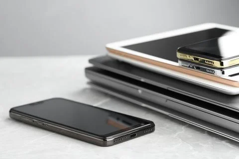 Stack of electronic devices on grey stone table, closeup Foto stock