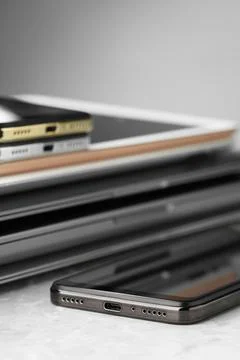 Stack of electronic devices on grey stone table, closeup Foto stock