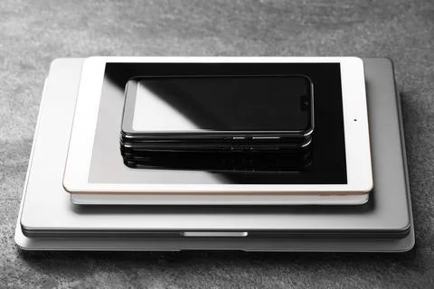 Stack of electronic devices on grey table, closeup Stock Photos