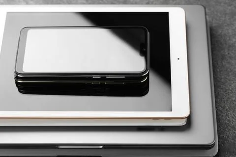 Stack of electronic devices on grey table, closeup 스톡 사진