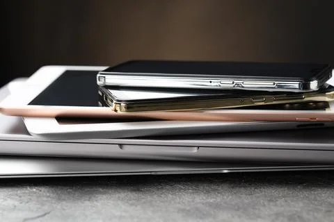Stack of electronic devices on grey table, closeup 스톡 사진