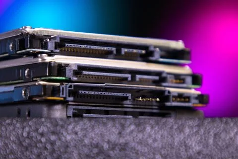Stack of electronic devices on a surface with colorful background lights in a 库存照片
