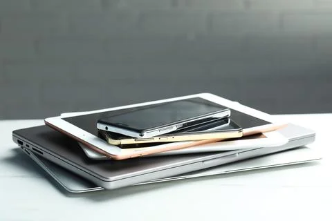 Stack of electronic devices on white table, closeup. Space for text Foto stock