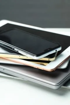 Stack of electronic devices on white table, closeup 스톡 사진