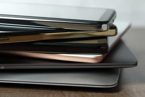 Stack of electronic devices on wooden table, closeup Foto stock