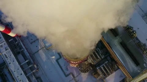 Stack emissions billow from a power plant during winter in a snowy landscape Stock Footage 312856538
