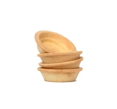 Stack of empty baked round canape baskets isolated on white background Stockfoto's