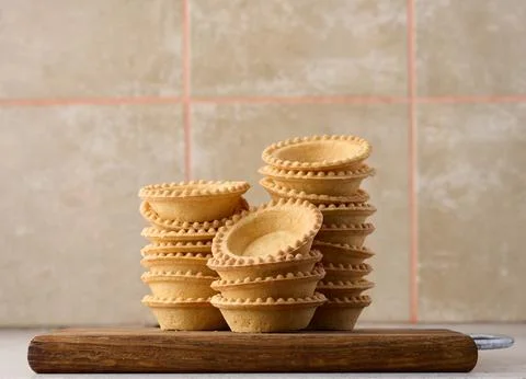Stack of empty baked round canape baskets on a wooden board, round empty ta.. Stock Photos
