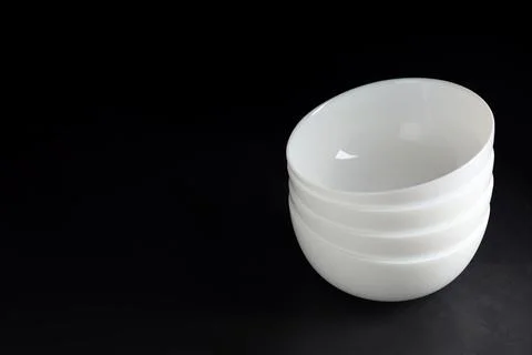 Stack of empty ceramic bowls on black stone table. Space for text 스톡 사진