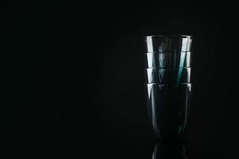 Stack of empty colorful glasses on black background, space for text Stockfoto's