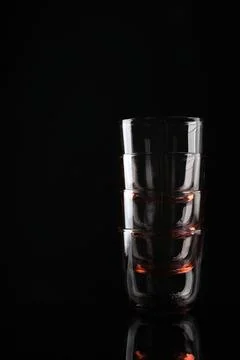 Stack of empty colorful whiskey glasses on black background, space for text Foto stock