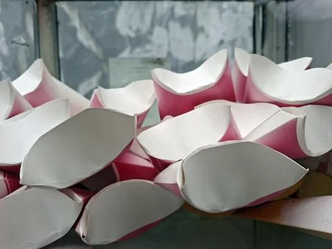 Stack of empty curved pink and white paper boxes or pillow food packaging i.. Stock Photos