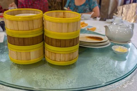 Stack of empty dimsum bamboo steamer boxes on dining table Foto stock