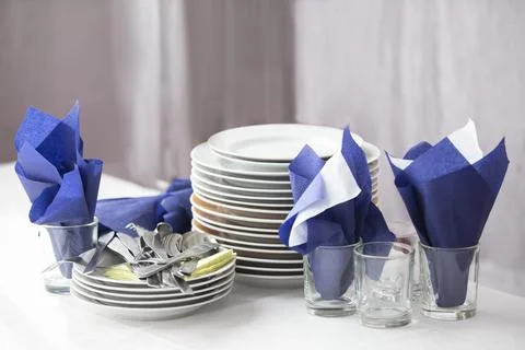 A stack of empty plates and napkins in a restaurant on a table. Stock Photos