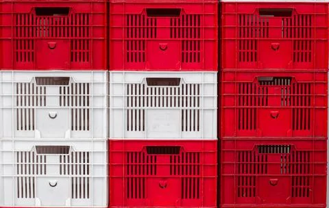 Stack of empty red and white plastic boxes for goods, textured. Stock Photos