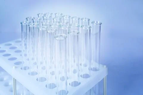 A stack of empty test tubes against a dark blue background Stock Photos
