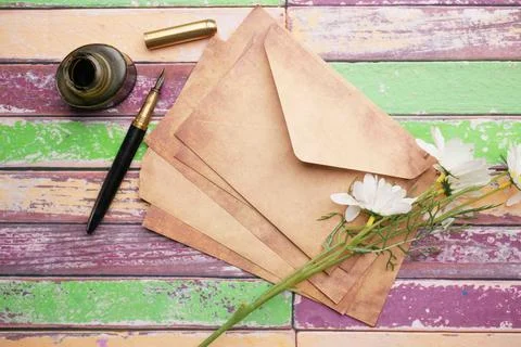 Stack of envelope , flower and fountain pen on table Stockfoto's
