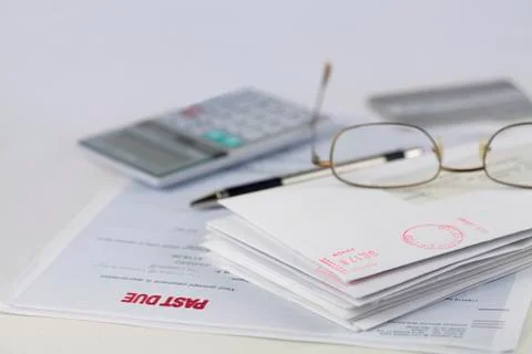 Stack of envelopes with pen, calculator, glasses and credit card Foto stock