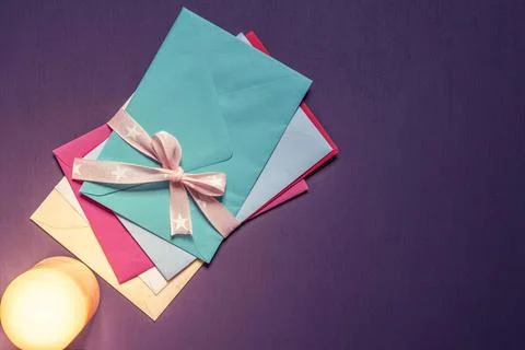 Stack of envelopes tied with bow in candlelight Bunch of multicolored lett... Foto stock
