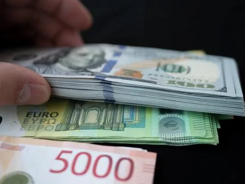 Stack of Euro and US Dollar Banknotes on Black Background Stock Photos