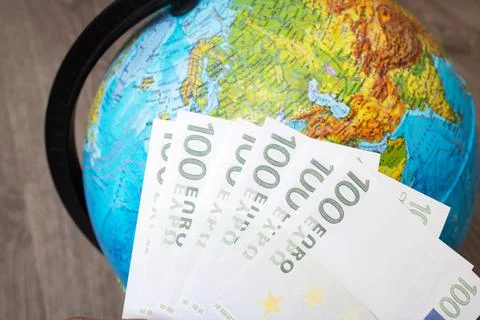 Stack of euro on background of globe with map Stock Photos