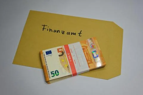 Stack of euro banknotes on envelope labeled with finance office text in Germa Stockfoto's