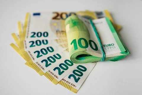 Stack of Euro banknotes including rolled 100 Euro note and several 200 Euro.. Stock Photos
