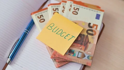 A stack of euro banknotes is shown with a yellow sticky note on top that reads Stock Footage 339094192