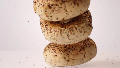 Stack of everything bagels bouncing on white slow motion macro food studio 4K Видео 337909871